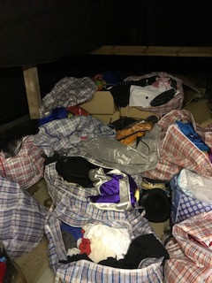 Lots of bags of clothes on an attic floor