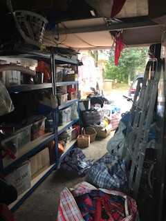 Inside a disorganised Garage filled with boxes, ladders and bikes