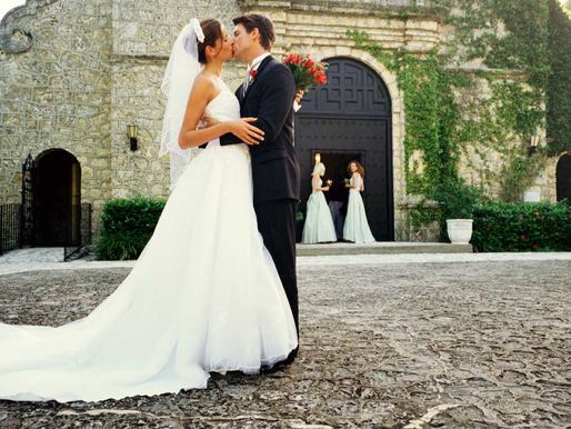Mariés qui s'embrassent devant l'église - organisation de mariage