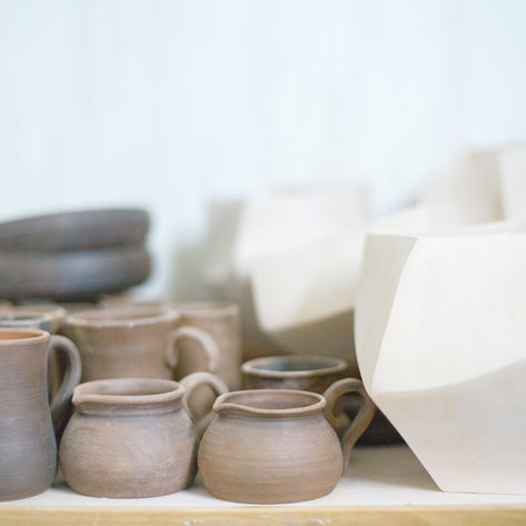 a stack of ceramic cups and pots on a kitchen top.