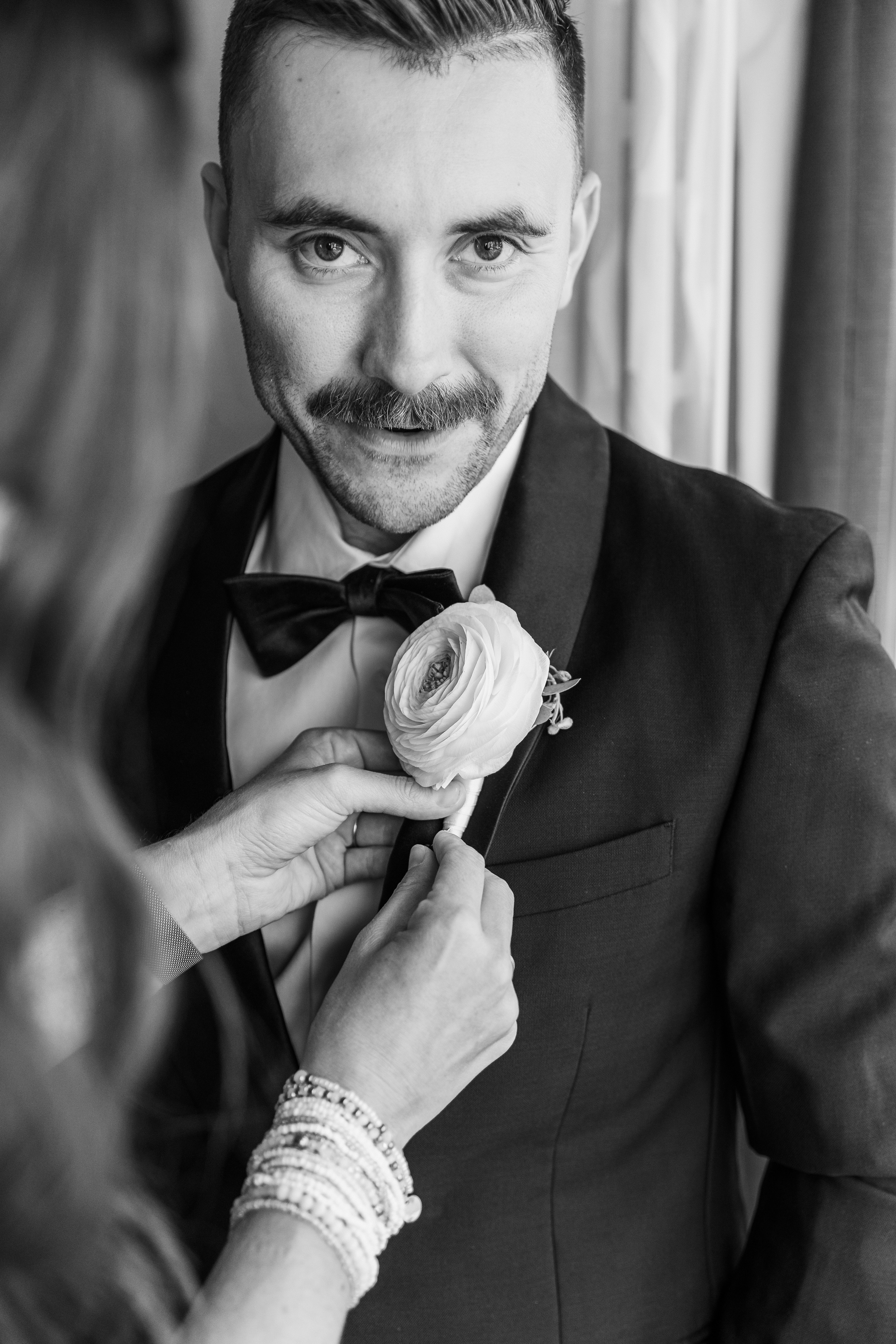 A groom adjusting his bowtie on his wedding day in Chicago