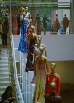 Valentino couture gowns displayed on a staircase installation at the Ara Pacis Museum retrospective.