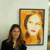 Dariya Repina standing beside a portrait painted by her mother, artist Lana Repina, at Gallery 40 in Stockholm, Sweden