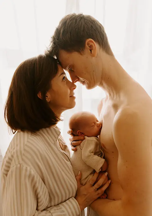 femme et homme face à face tête contre tête avec bébé dans les bras