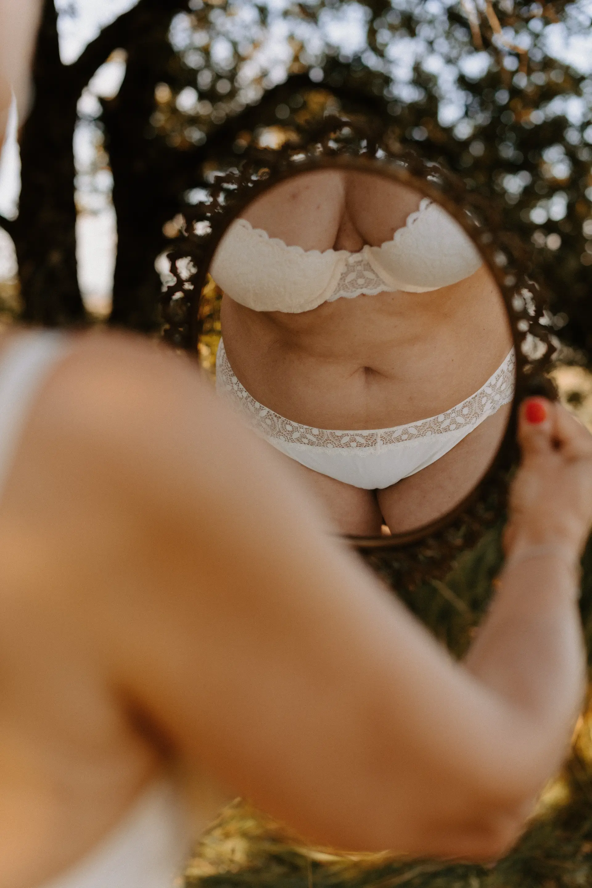 Femme se regardant dans le miroir en lingerie blanche, Every-Body : estime de soi.
