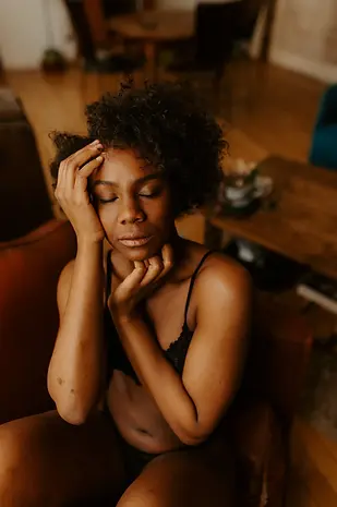 Femme afro fermant les yeux les mains sur son visage