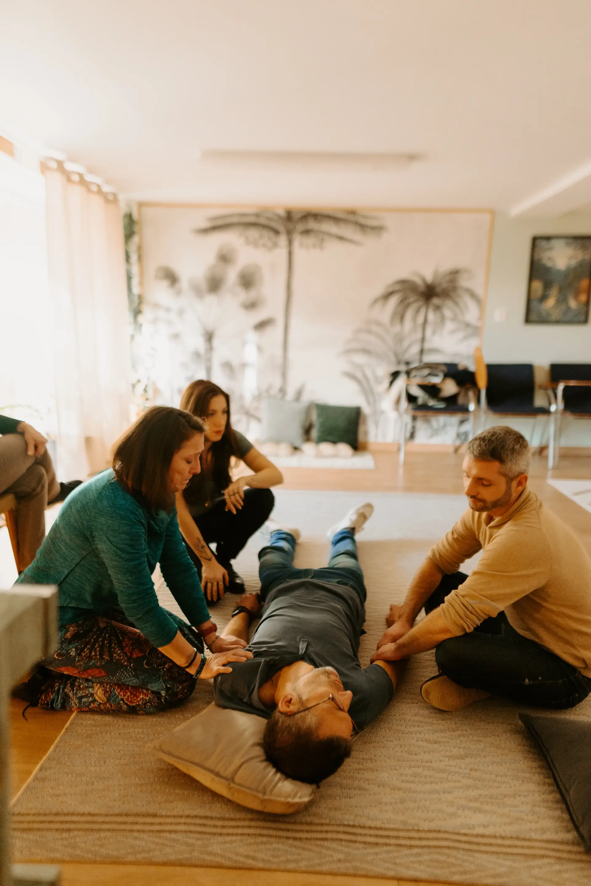 Participants entourent une personne allongée, scène de Constellations familiales. Un reportage photo professionnel amandine-dirand.