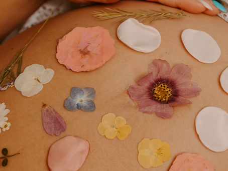pétales de fleurs déposer sur le ventre d'une femme enceinte
