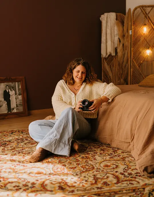 Femme tenant un appareil photo assise par terre