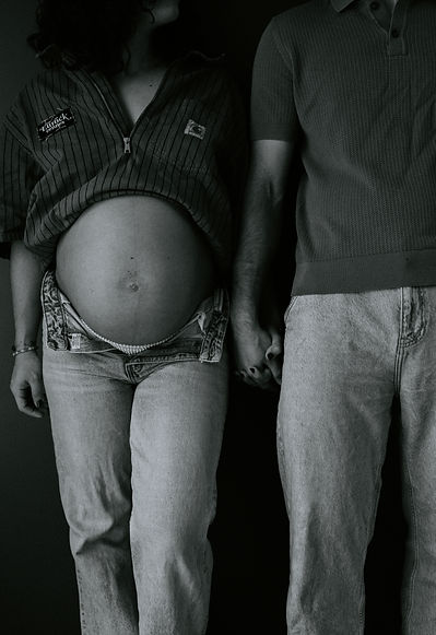 gros plan sur ventre femme enceinte et son conjoint se tenant la main