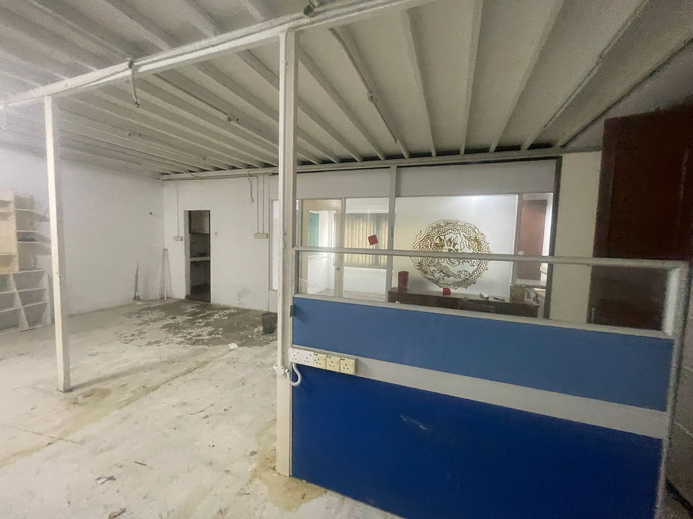 Original upper-floor office and storage area with worn flooring, old partitions and exposed steel structures before renovation.