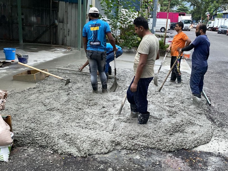 Workers placing and levelling reinforced concrete for the new heavy-duty warehouse floor and loading access.