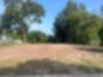 Cleared land plot surrounded by trees for a new project.