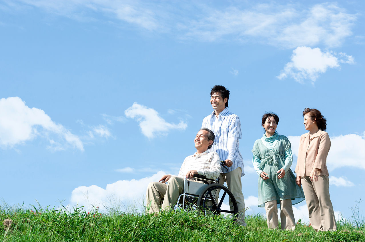 車椅子に座るシニア男性と笑顔の家族