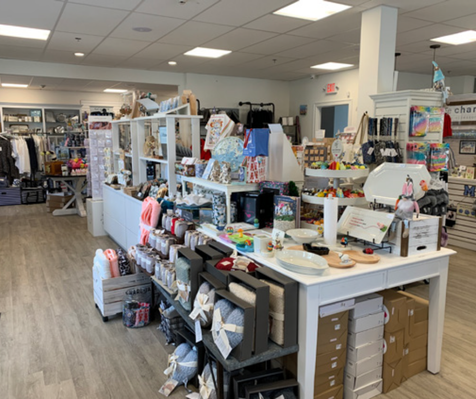 The interior of a gift store, which a large table at the centre of the image, displaying gift stock.