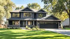 Front view of a modern Maple Grove, MN home with dark-framed energy-efficient windows and updated exterior after professional window installation.