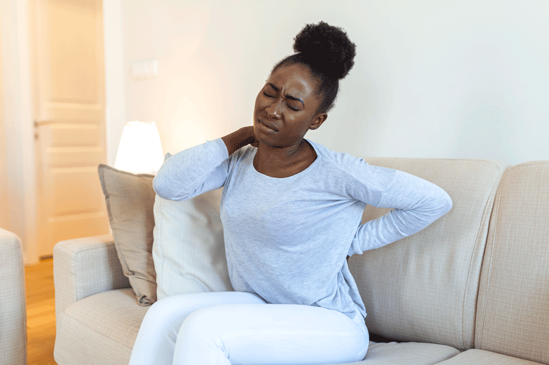young-black-woman-suffering-from-backache-home-portrait-young-girl-sitting-couch-home-with
