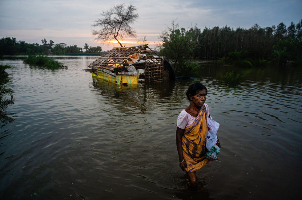 A woman walks through flooded fields