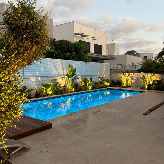 בריכת שחייה כחולה עם בית לבן ברקע, בריכות ומה שמסביב, תאורת גן יפהפייה.