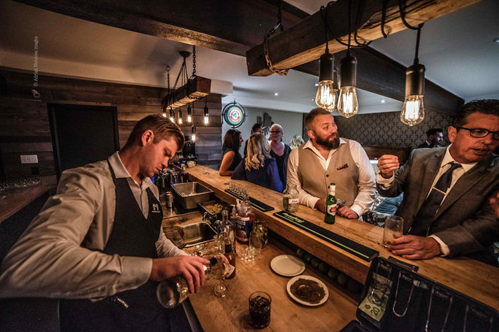 Serveur derrière le bar qui sert des breuvages.