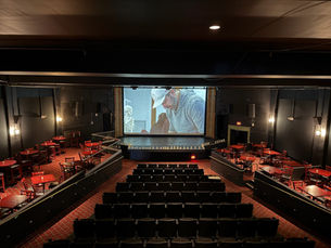 Empty Bijou Theatre in Bridgeport with the Barnum Museum documentary projected on the main screen during pre-screening setup before the audience arrived.