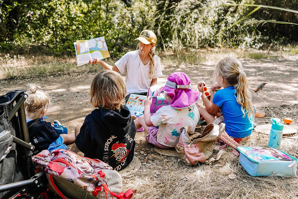 Children sitting together during snack time and listening to a story at Buena Vista Park in Vista, building community and early literacy skills at a nature school.