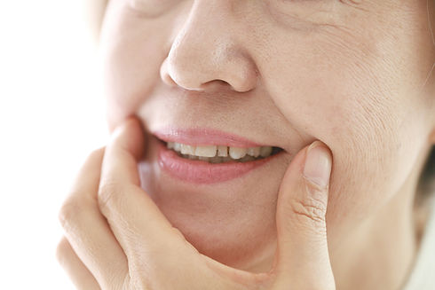 older woman touching her face