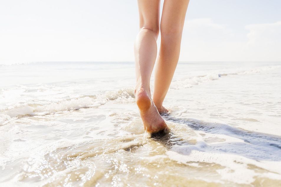 view of feet and legs of woman on beach
