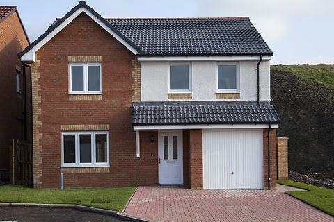 White garage door on a modern two-storey house with a paved driveway