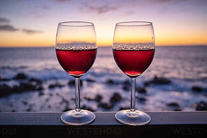 two-glasses-of-red-wine-with-sea-at-sunset-in-background-SIEF10065.jpeg