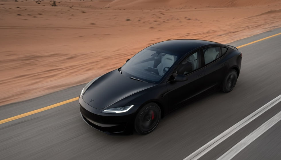 A Matte Black Tesla Model 3 2024 drives on a road next to the desert