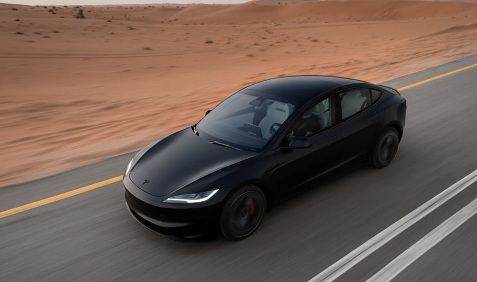 Ein mattschwarzes Tesla Model 3 2024 fährt auf einer Straße neben der Wüste