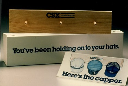 Fourth of 4 boxed mailings -- "Here's The Capper!" — emabl d receipient to hand3 hats already received on this hat rack.