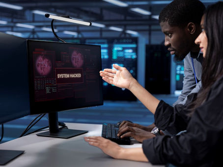 Dois profissionais analisam um alerta de crise cibernética em um monitor, dentro de um ambiente de segurança digital.