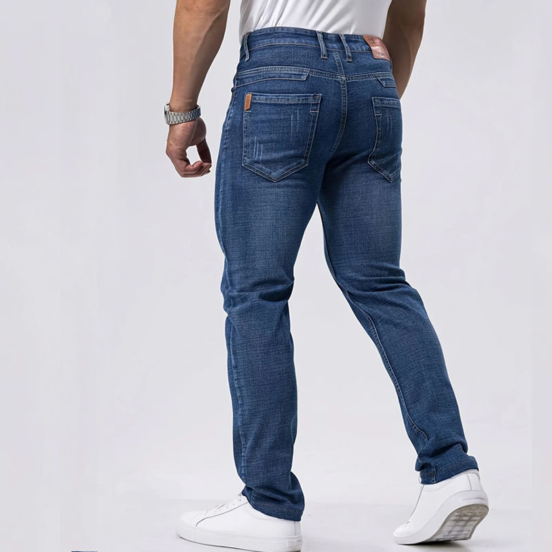 Mann von hinten in blauer Jeans und weißen Sneakern.