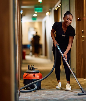 young-black-maid-vacuuming-hallway-while-working-i-2024-12-13-18-32-59-utc.jpg