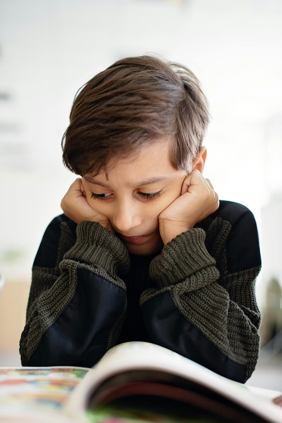 Child sitting alone looking down, carrying the silent weight of childhood trauma