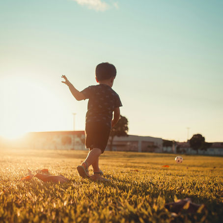 Young child running freely in a field at sunset, full of joy and possibility