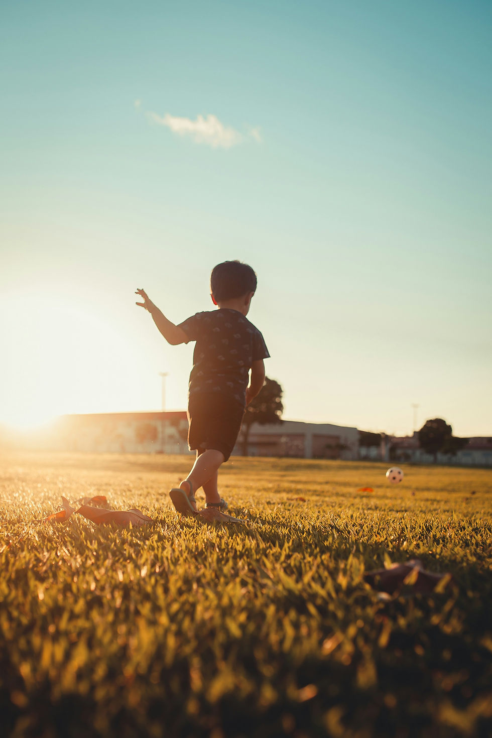 Young child running freely in a field at sunset, full of joy and possibility