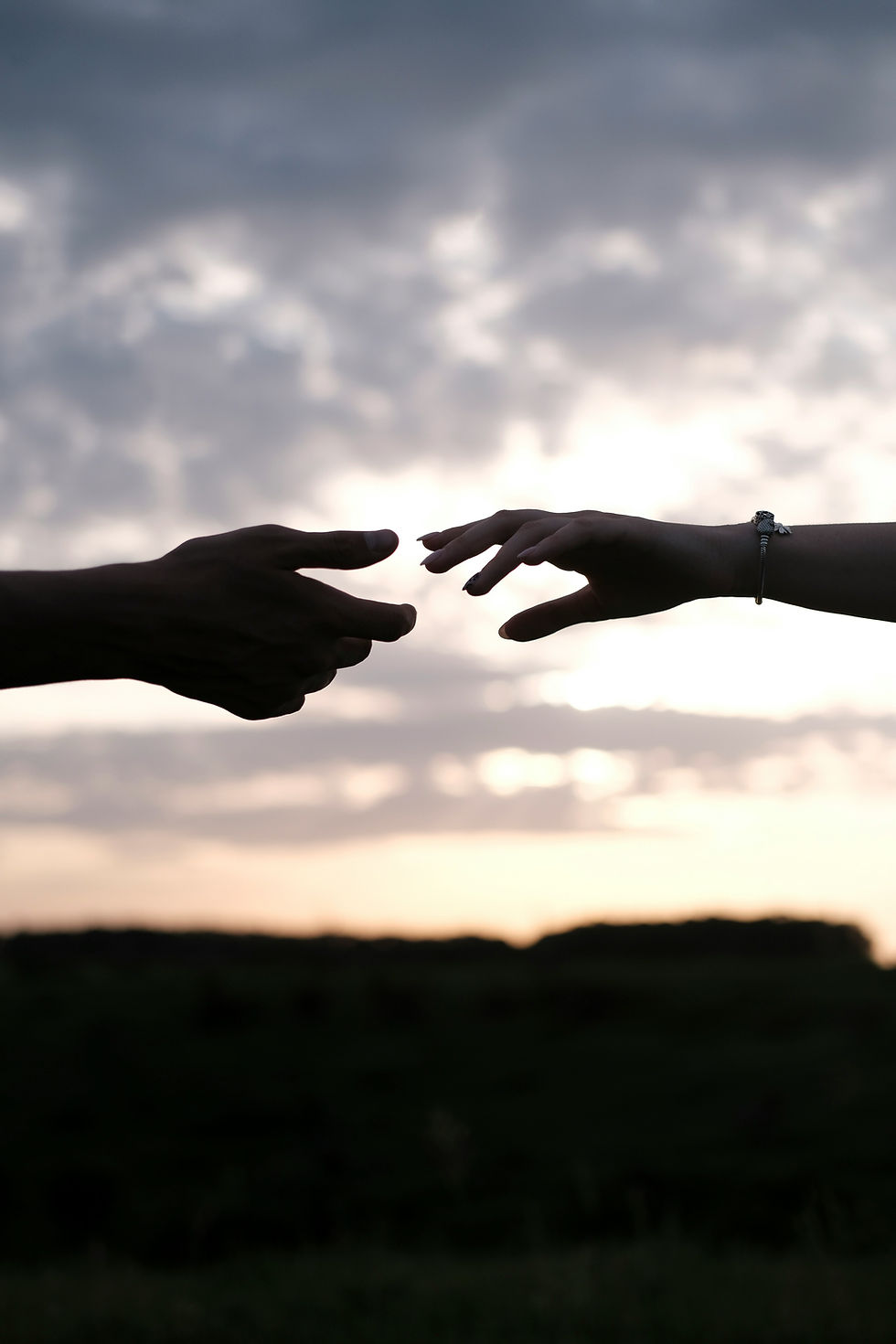 Two hands reaching toward each other but not quite touching
