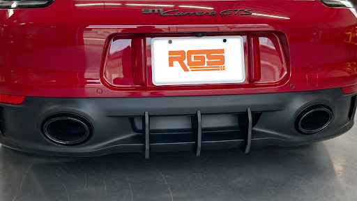 Rear view of a red Porsche 911 showing the bumper area and diffuser fins beneath the license plate.