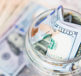 Several dollar bills in a jar