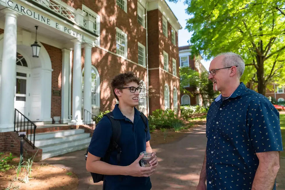 Eric Hall talking with a student on campus