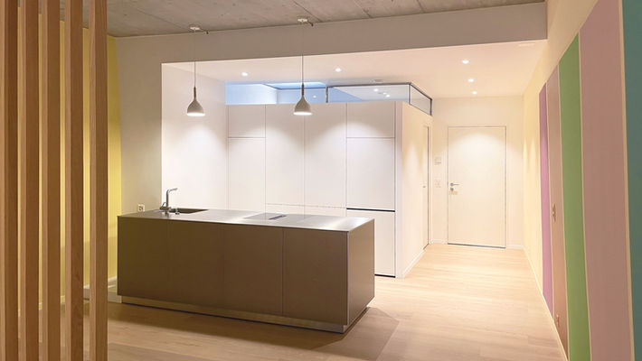 Cuisine ouverte
Îlot inox Alu Bulthaup
Bloc armoires murales blanches
Bandeau vitré
Verrière intérieure translucide
Second jour
Parquet massif chêne clair
Béton apparent plafond
Séquence couleurs 
Fresque murale colorée contemporaine 