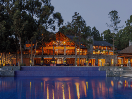Carmelo Resort & Spa à noite, com piscina iluminada e atmosfera romântica no Uruguai. 
