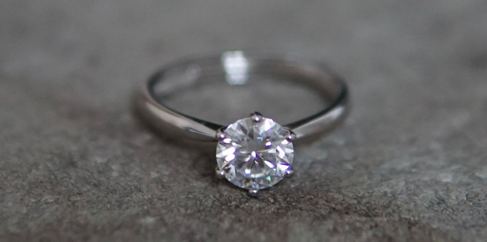 Eye-level view of a rose gold ring with a cushion cut diamond on a wooden surface