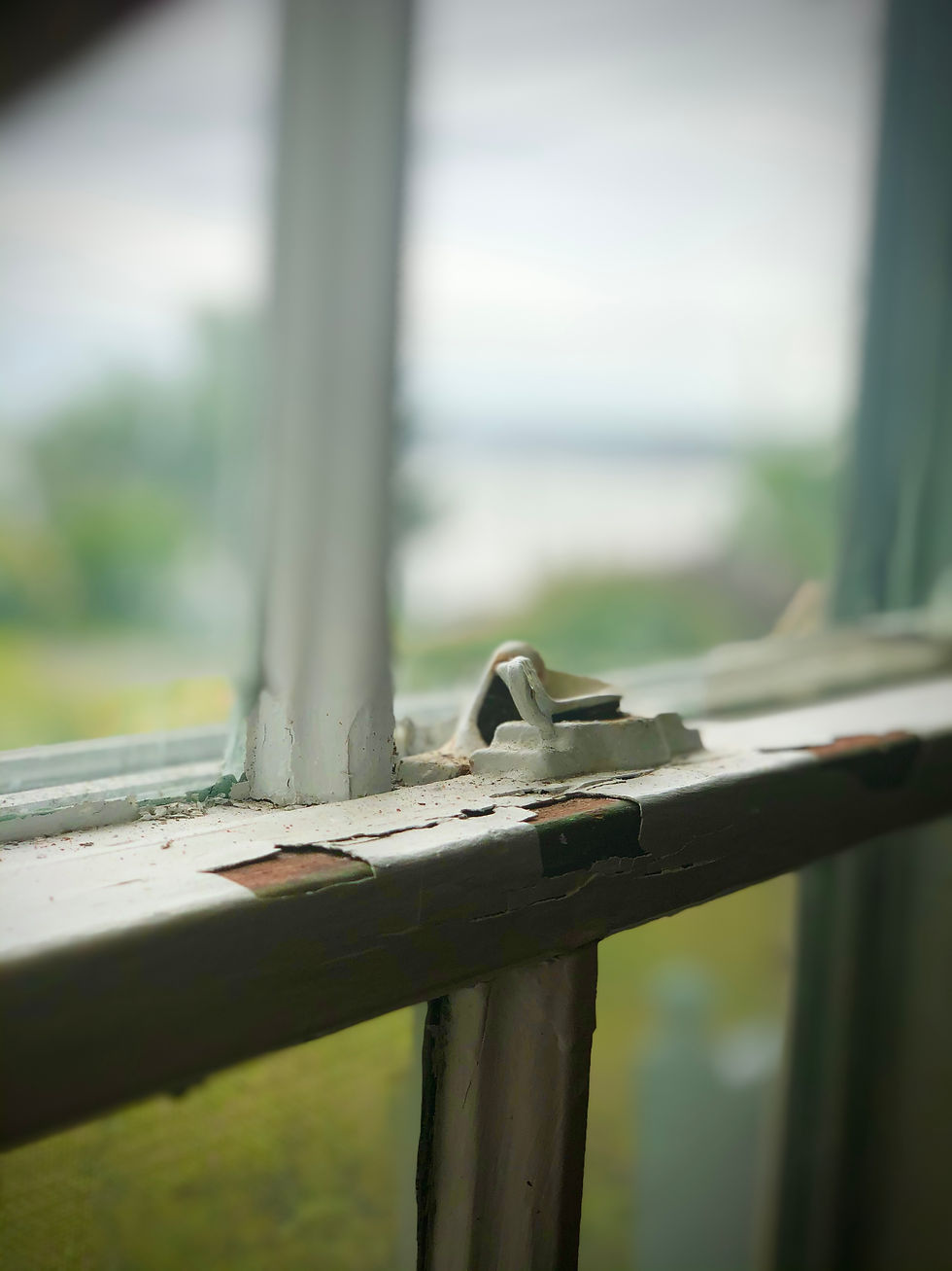 A view from the window of the Captain’s House with the shoreline and the Bay of Fundy out of focus in the distance.