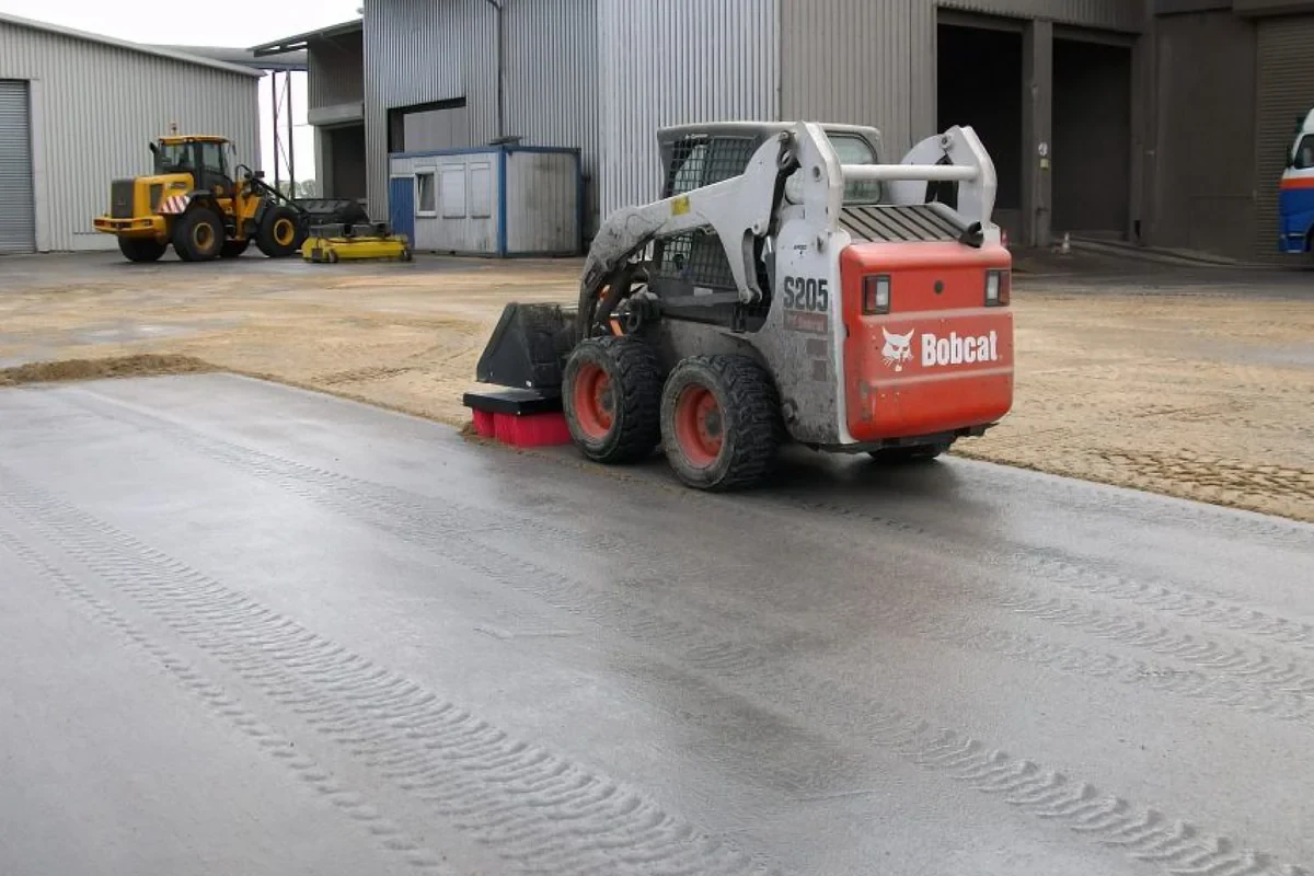 CLEANsweep V-Concept® kehrt Sand/Feinstaub mit Kompaktlader – Betriebshof/Halle