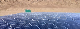 Solar panel farm in a desert landscape with mountains.