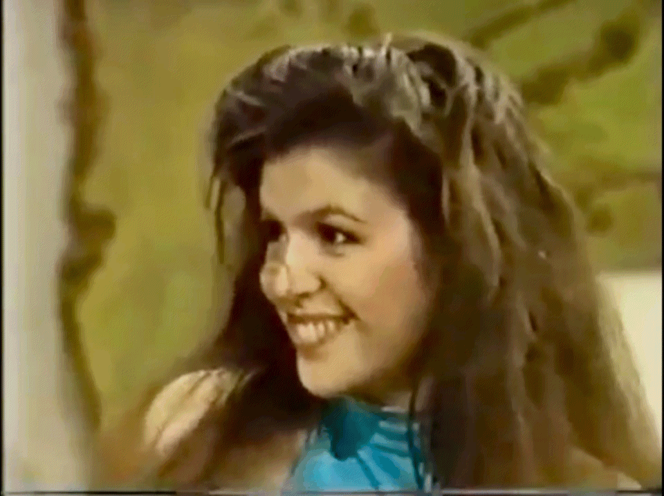 Anna smiling and waving her head side to side on a mission with Robert in the 70s